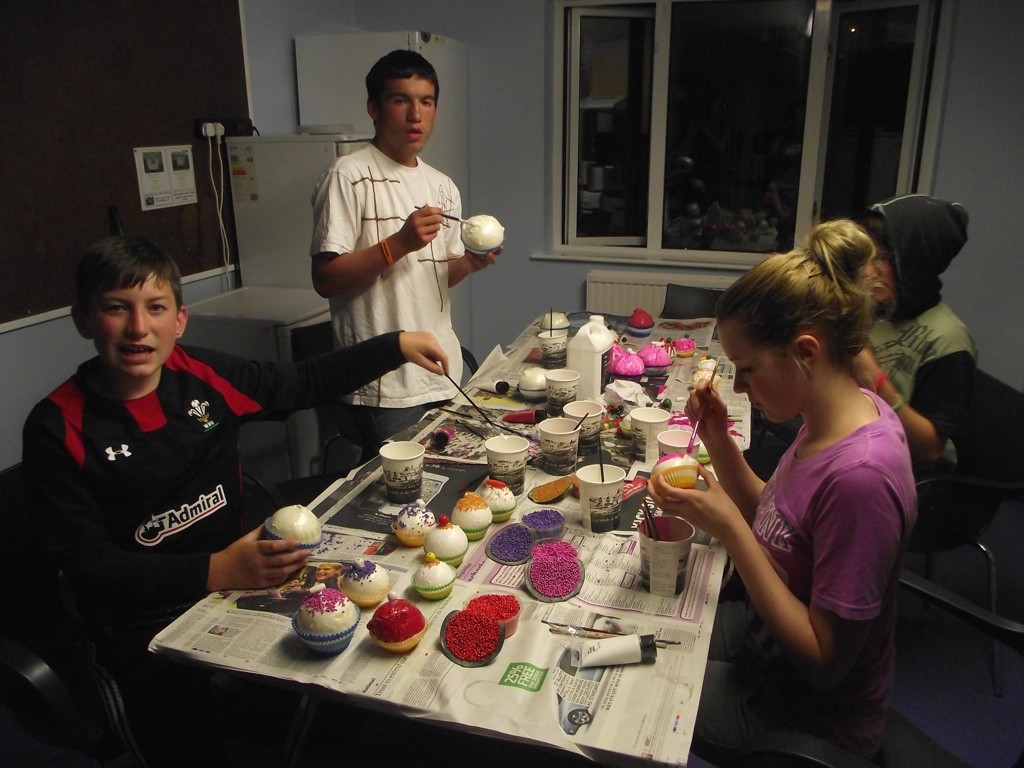 Young people painting cupcake props